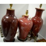 Selection of three red ceramic table lamps.