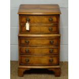 A reproduction miniature chest of drawers