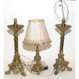 Pair of ornate brass oil lamps (converted); and a brass table lamp.