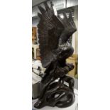 Carved wooden sculpture of an eagle on a perch.