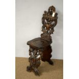 A late 19th Century continental carved oak hall chair
