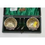 A pair of silver shell pattern table salts, by Lockwood Brothers
