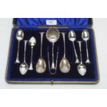 A George V silver teaspoons, tongs and caster spoon
