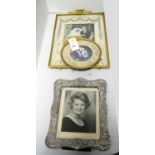An Edwardian silver photograph frame; and two gilt metal photograph frames.