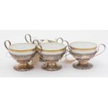 A set of four Limoges porcelain bowls in sterling silver two-handled stands