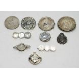 A selection of silver and white metal brooches,