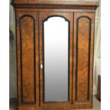 A Victorian burr walnut and ebonised three door wardrobe.