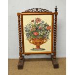A Victorian rosewood firescreen with needlework panel.