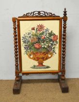 A Victorian rosewood firescreen with needlework panel.