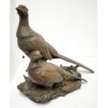 A bronzed resin sculpture of a pair of pheasants.