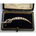 An early 20th Century opal crescent brooch,