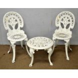 A white-painted cast iron garden table and chairs.