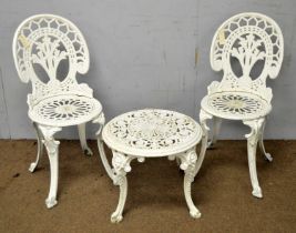 A white-painted cast iron garden table and chairs.