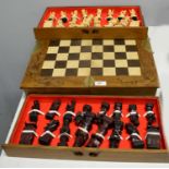 A 20th Century stained and carved wood chessboard and pieces.