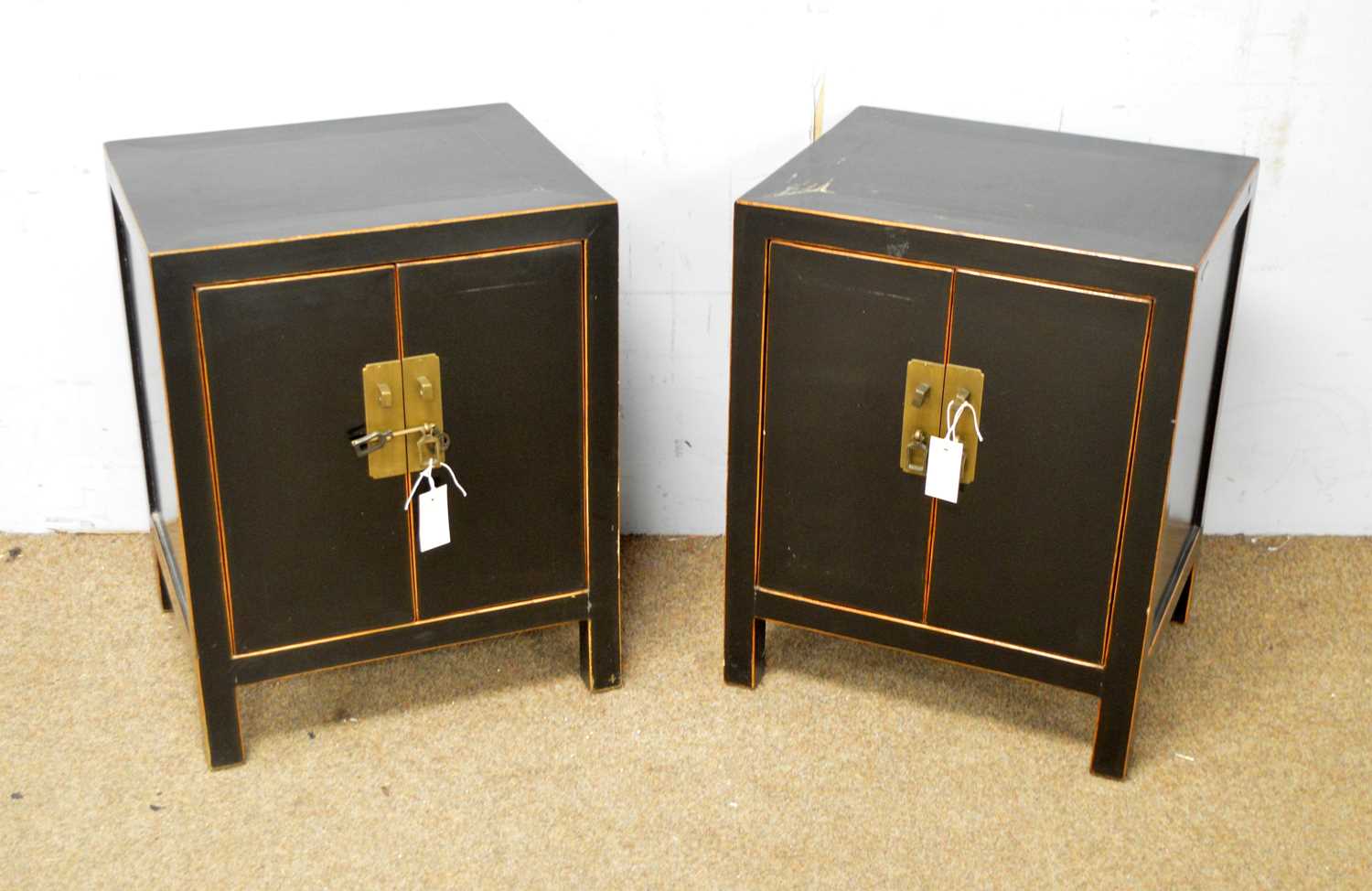 A pair of Asian black lacquer and gold painted bedside chests.