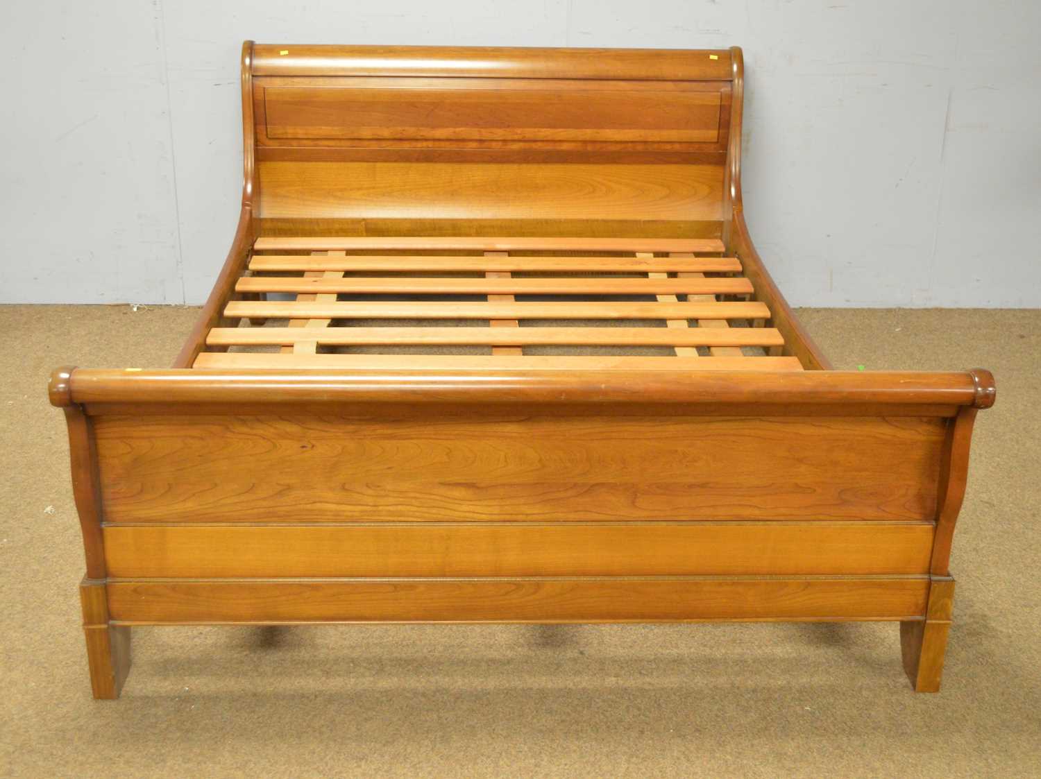 A modern French cherry wood sleigh bed