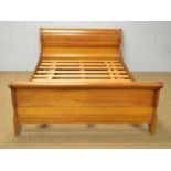 A modern French cherry wood sleigh bed