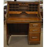 An early 20th Century oak roll top desk