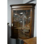 An oak wall mounted corner cupboard.