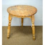 A circular pine cricket table