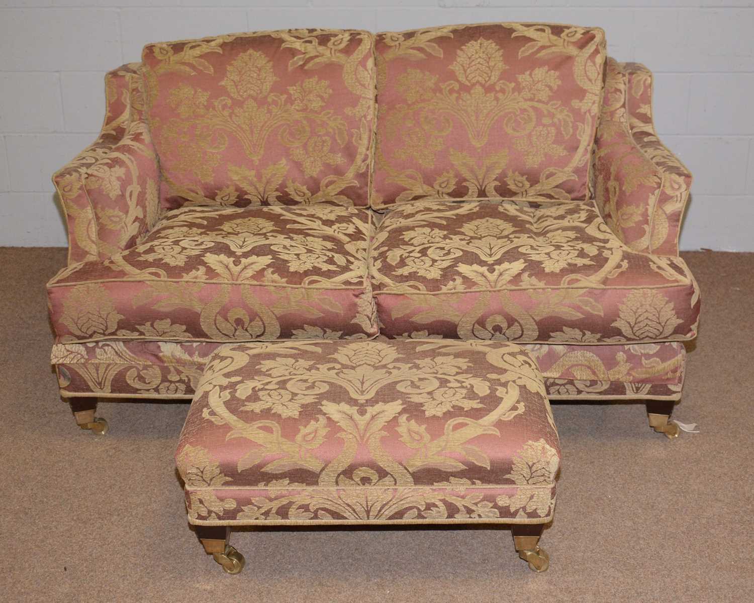 A modern two seater settee and footstool.