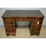 A small 20th Century mahogany serpentine pedestal desk