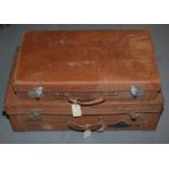 Two vintage brown leather suitcases.