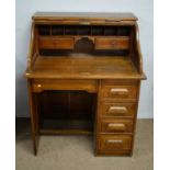 An early 20th Century medium oak roll top desk