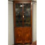 A George III inlaid corner cupboard.