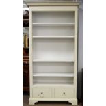 A cream painted open bookcase.