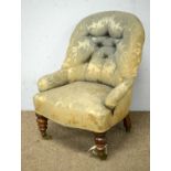 A Victorian child's button-back salon chair on turned front supports and casters.
