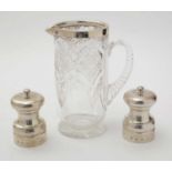 A pair of silver mounted pepper mills, and a silver mounted cut glass jug.