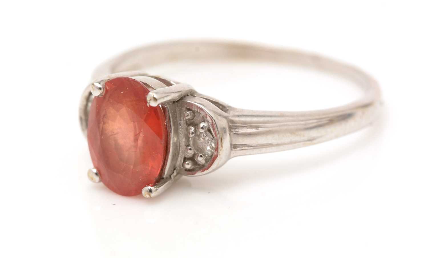 An orange sapphire and diamond ring,