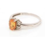 An orange sapphire and diamond ring,