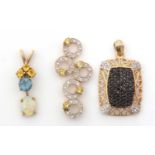 Three gemset pendants, one with opal, topaz and orange sapphires, one yellow and white stones, the