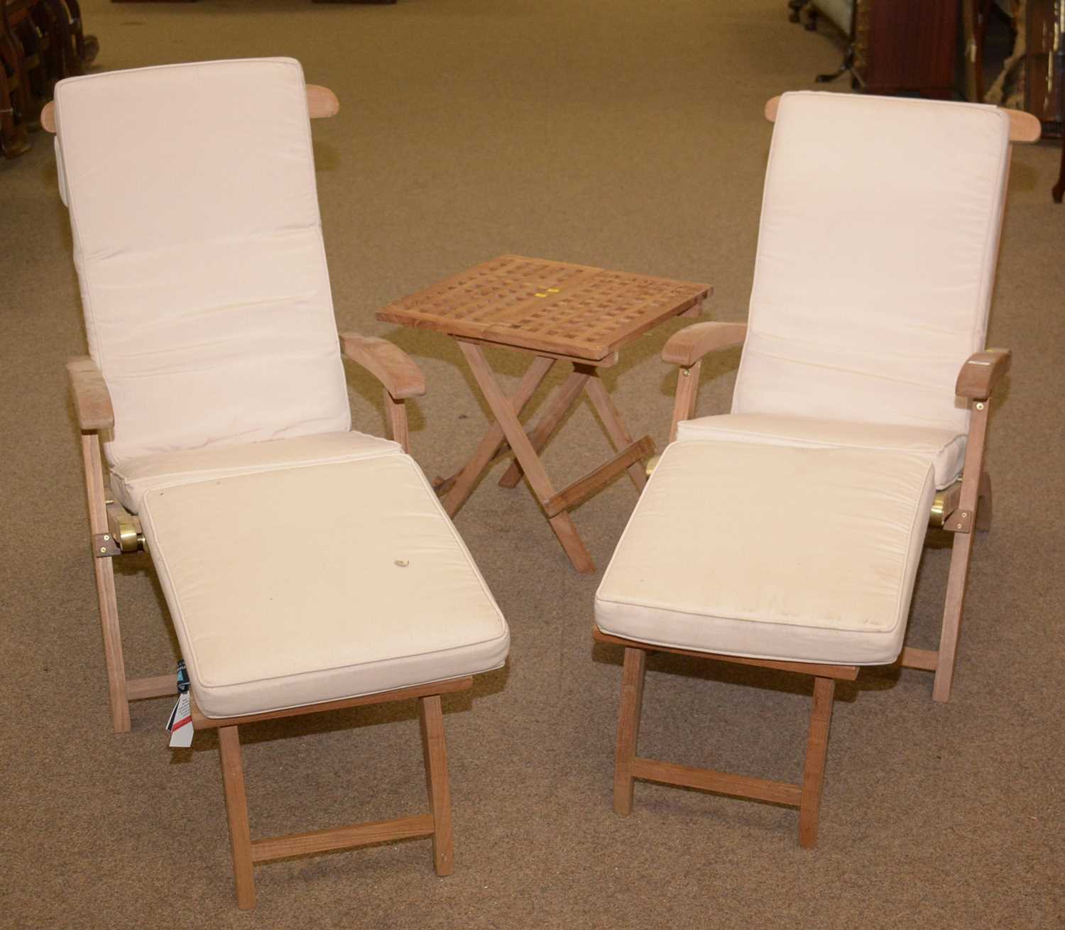 A pair of modern reclining garden chairs; and a folding table.