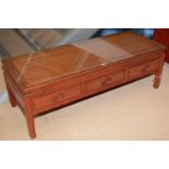 A Chinese hardwood three drawer side table/TV stand.