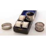 A set of four silver napkin rings, and two others.