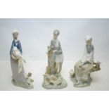 A collection of three Lladro figures of children.