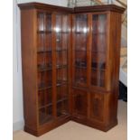 A Victorian-style mahogany two-piece corner bookcase.