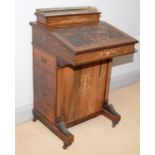 A Victorian carved and inlaid rosewood Davenport.