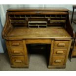 An early 20th century oak roll top desk