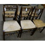 Six 19th Century rustic oak and ash rush seated dining chairs: and a Georgian elbow chair.