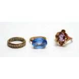 An amethyst ring, a topaz ring and an eternity ring.