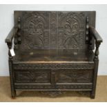 A Victorian stained and carved oak monks bench.