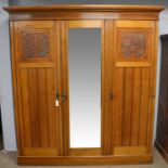 An Edwardian carved walnut wardrobe