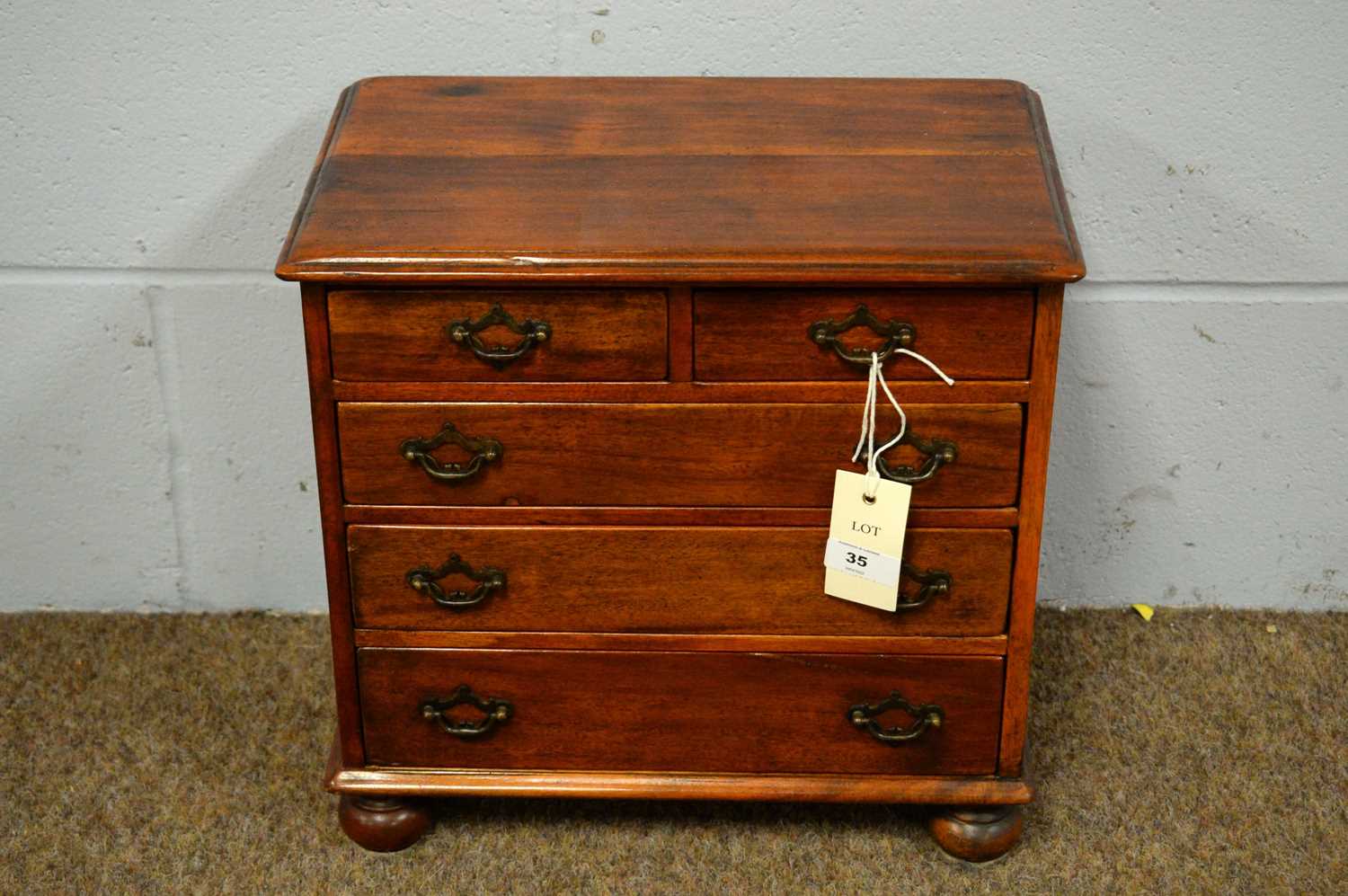 A Victorian-style mahogany apprentice chest of drawers.