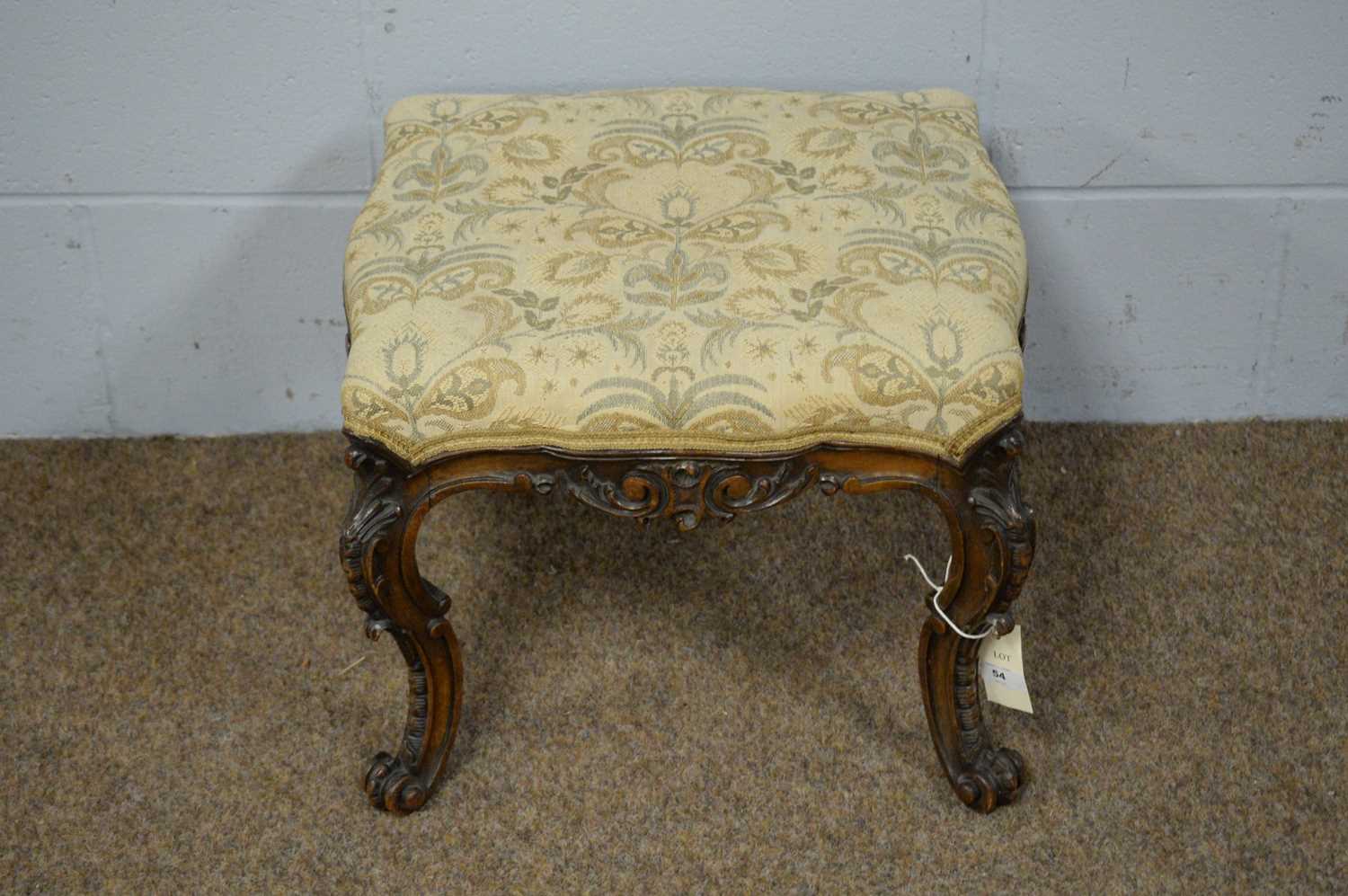 An ornate Victorian carved walnut footstool