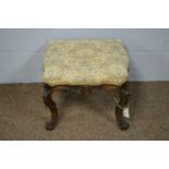 An ornate Victorian carved walnut footstool