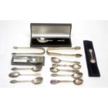 A selection of silver teaspoons and tongs.